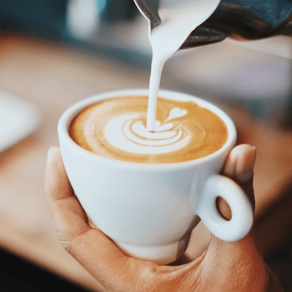Barista wlewający mleko do latte